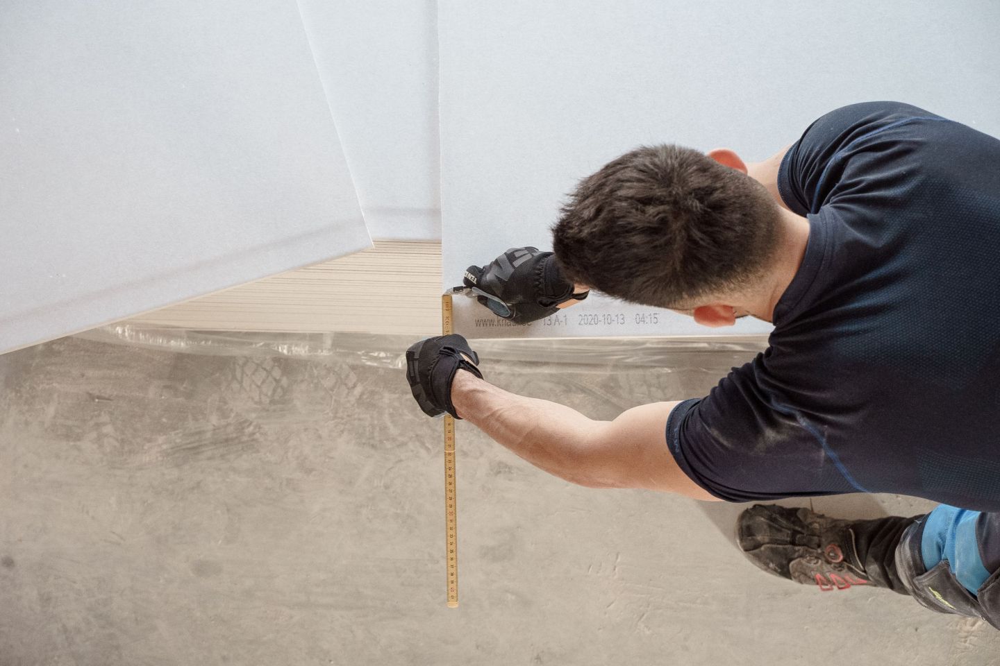 Handwerker schneidet auf einer Baustelle eine Bodenplatte für den Anschluss an die Wand zu